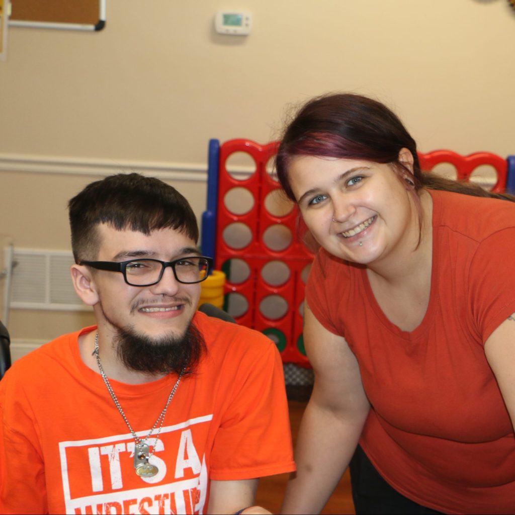 Staff posing with patient with disability